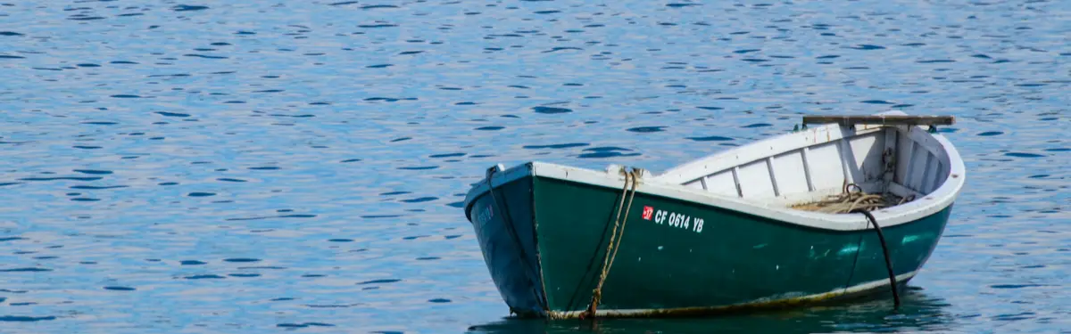 empty rowboat floating on body of water